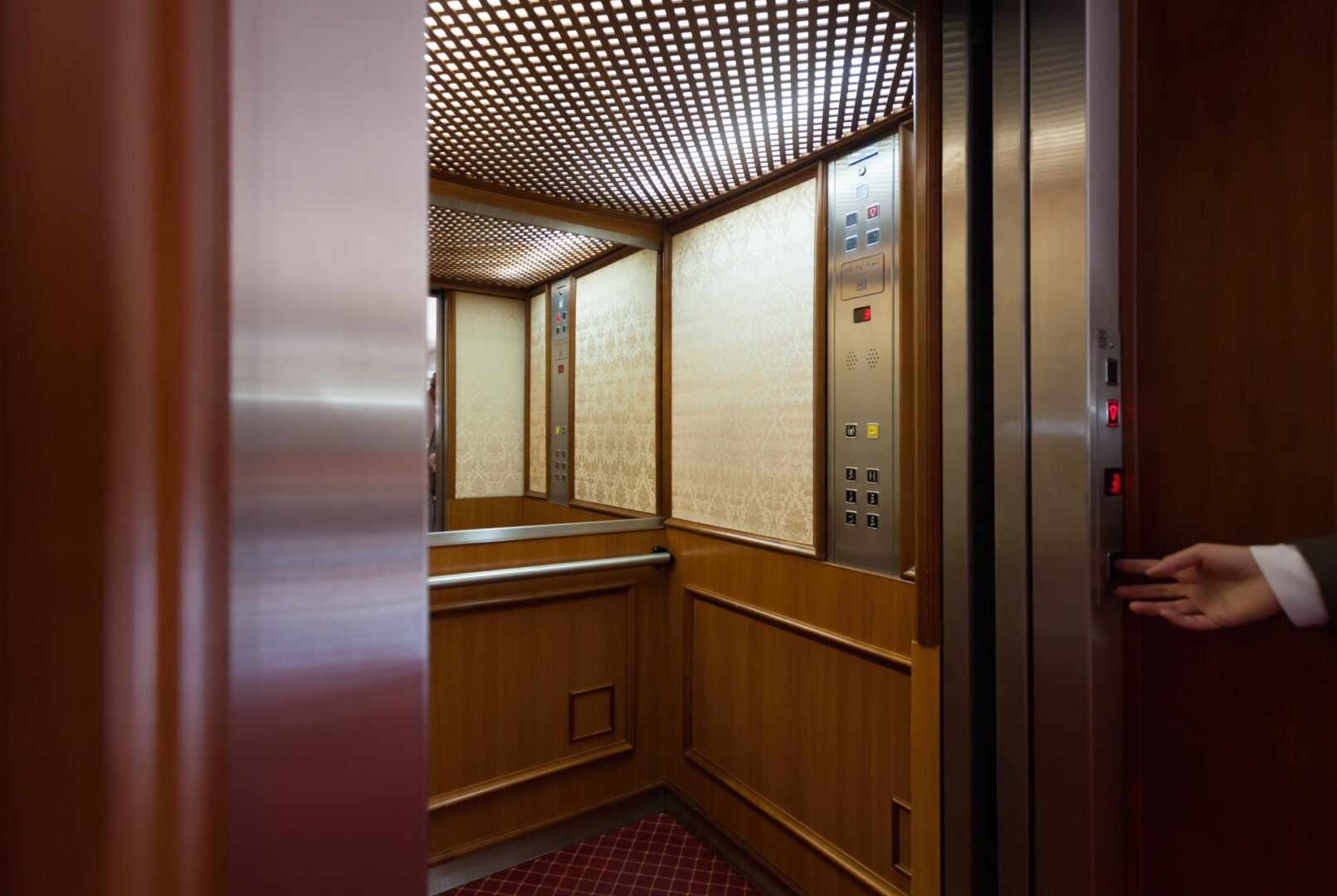 Renovated elevator cab with mahogany paneling and brass handrail