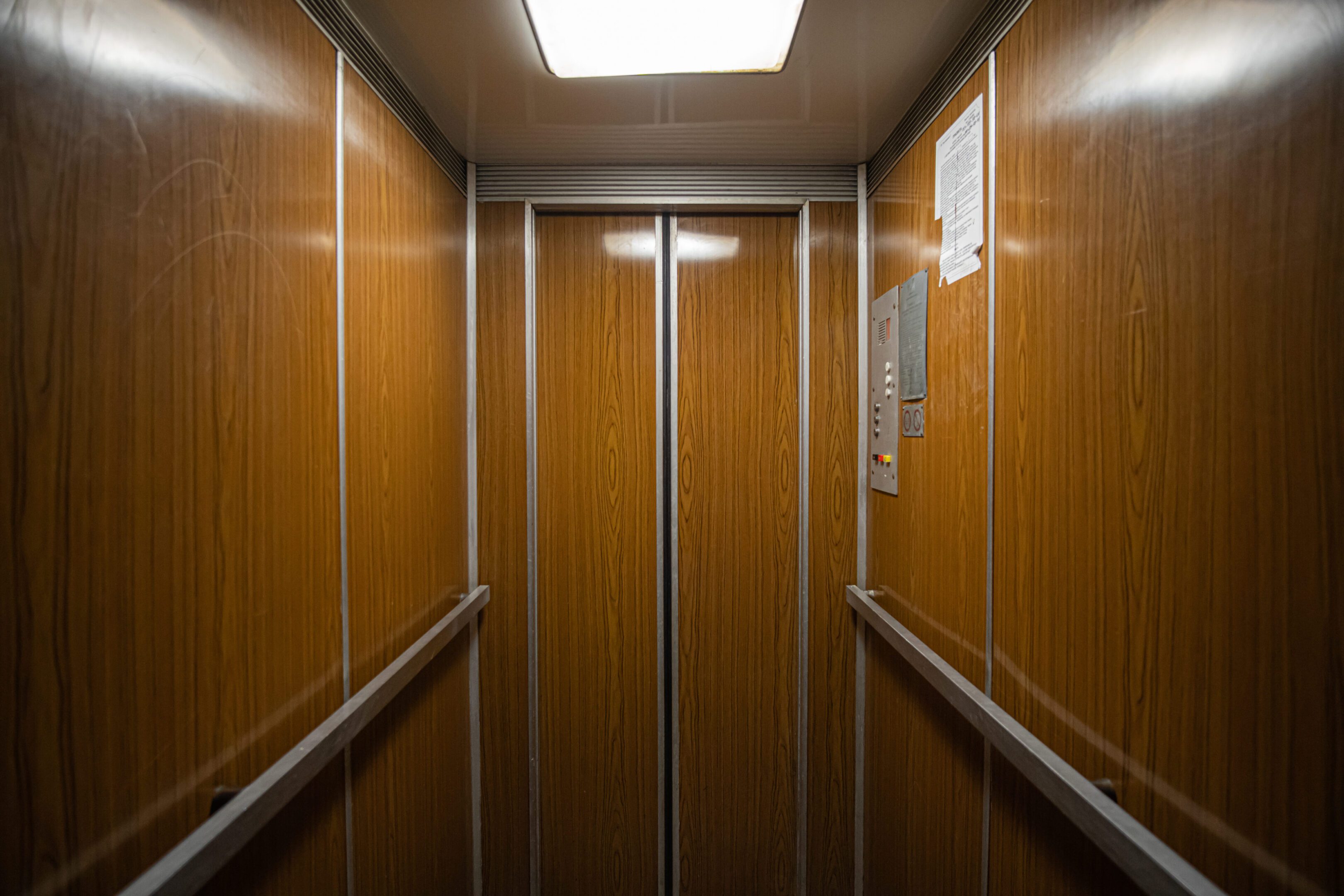 Custom wood panel elevator cab interior fabricated by Manhattan Elevator Interiors